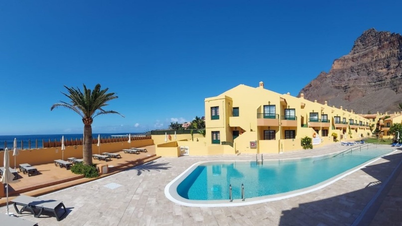 Apartamentos Tres Palmeras Apartamentos 3 Palmeras dispuestos alrededor de la zona de piscina, con tumbonas y sombrillas, vistas al mar y la montaña